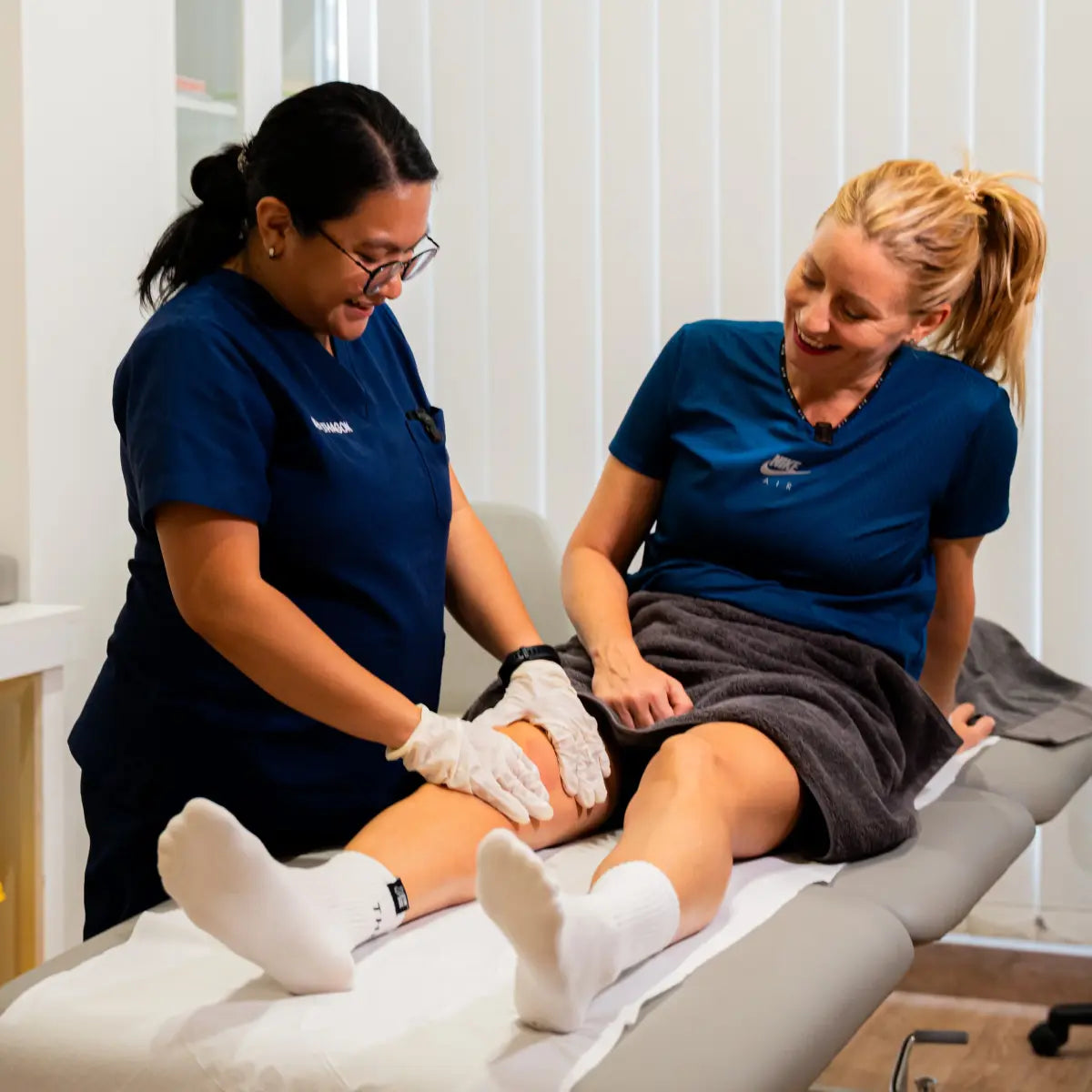 Healthagon practitioner assessing a patient's knee during a consultation
